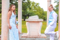 a man and a woman pose for a photo in front of a pillar